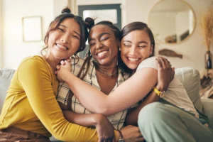Women supporting each other with a group hug during addiction treatment and recovery