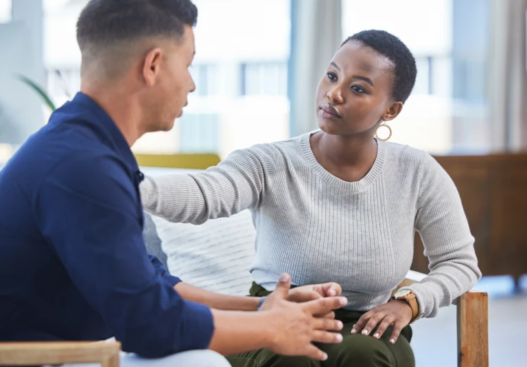 Two people sitting together in a supportive conversation about mental health and addiction recovery.